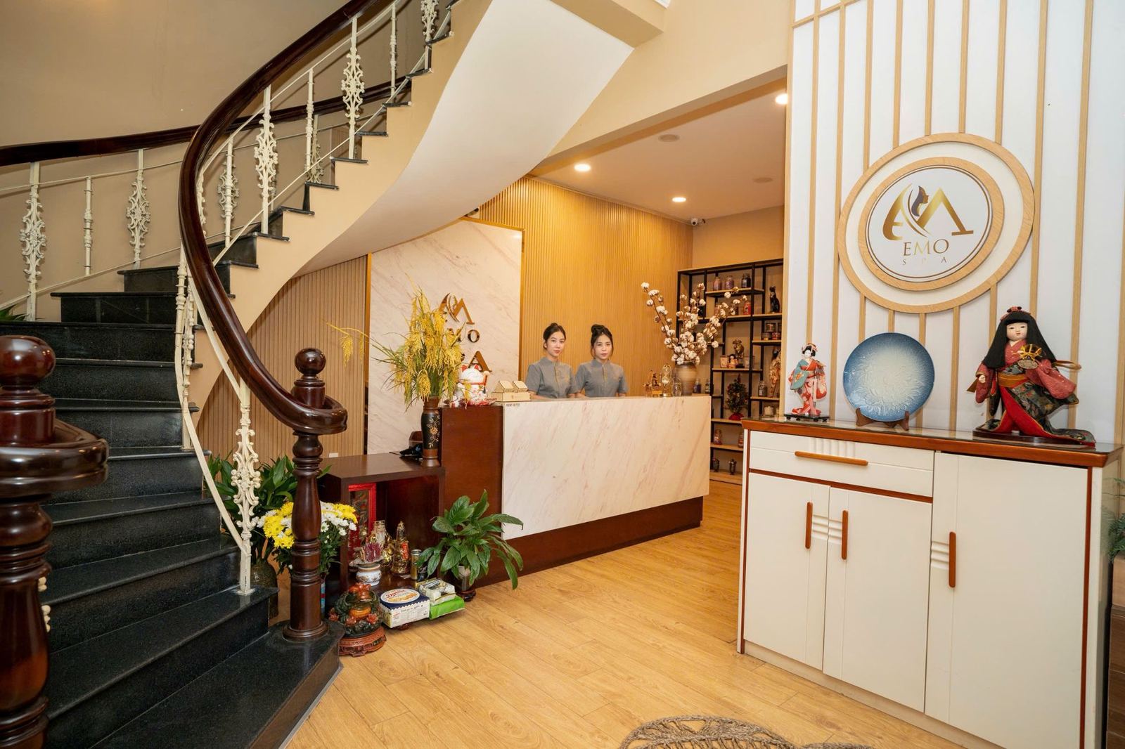 Sảnh lễ tân sang trọng tại EMO SPA với không gian đá marble và cầu thang xoắn